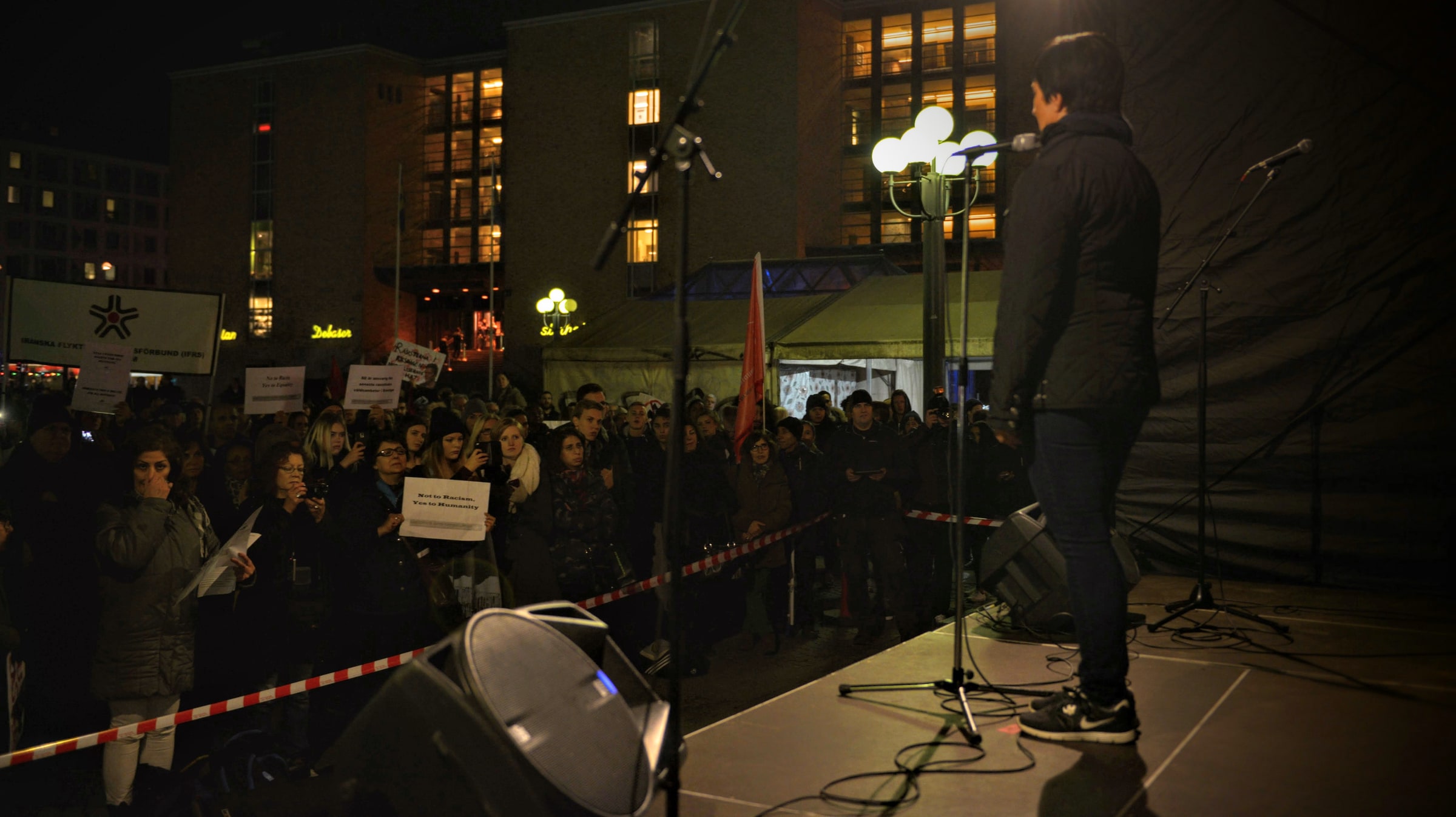 A crowd at a Stockholm manifestation holds a sign reading No to Racism, Yes to Humanity.