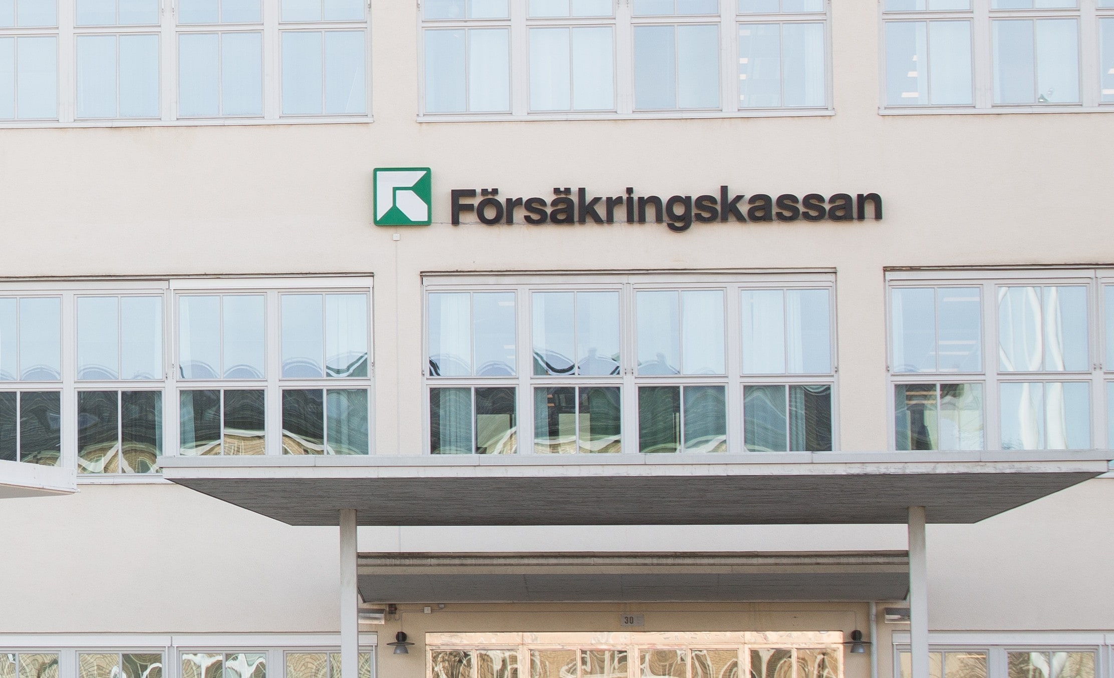 The Försäkringskassan name and green logo on the agency’s head-office façade in Stockholm.
