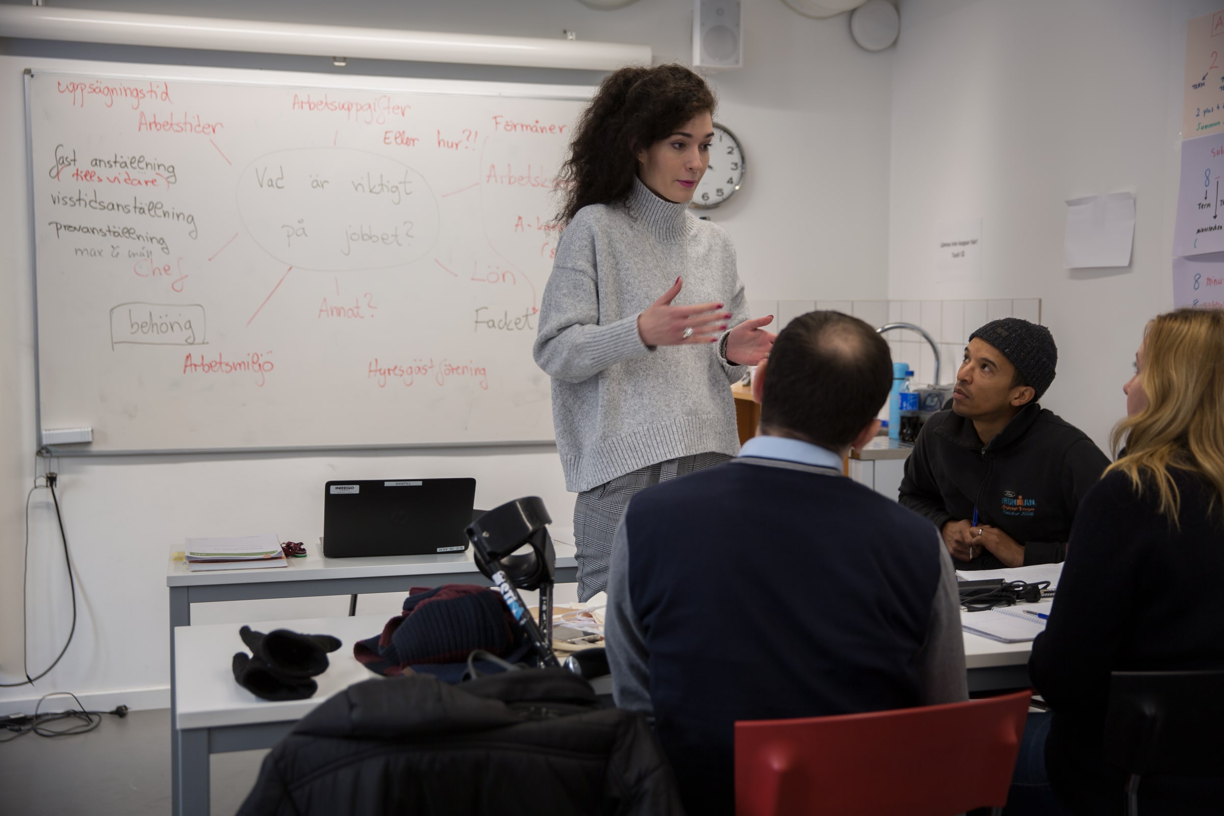 A teacher gestures beside a whiteboard as adults listen during a Swedish-language lesson in Lund in 2018.
