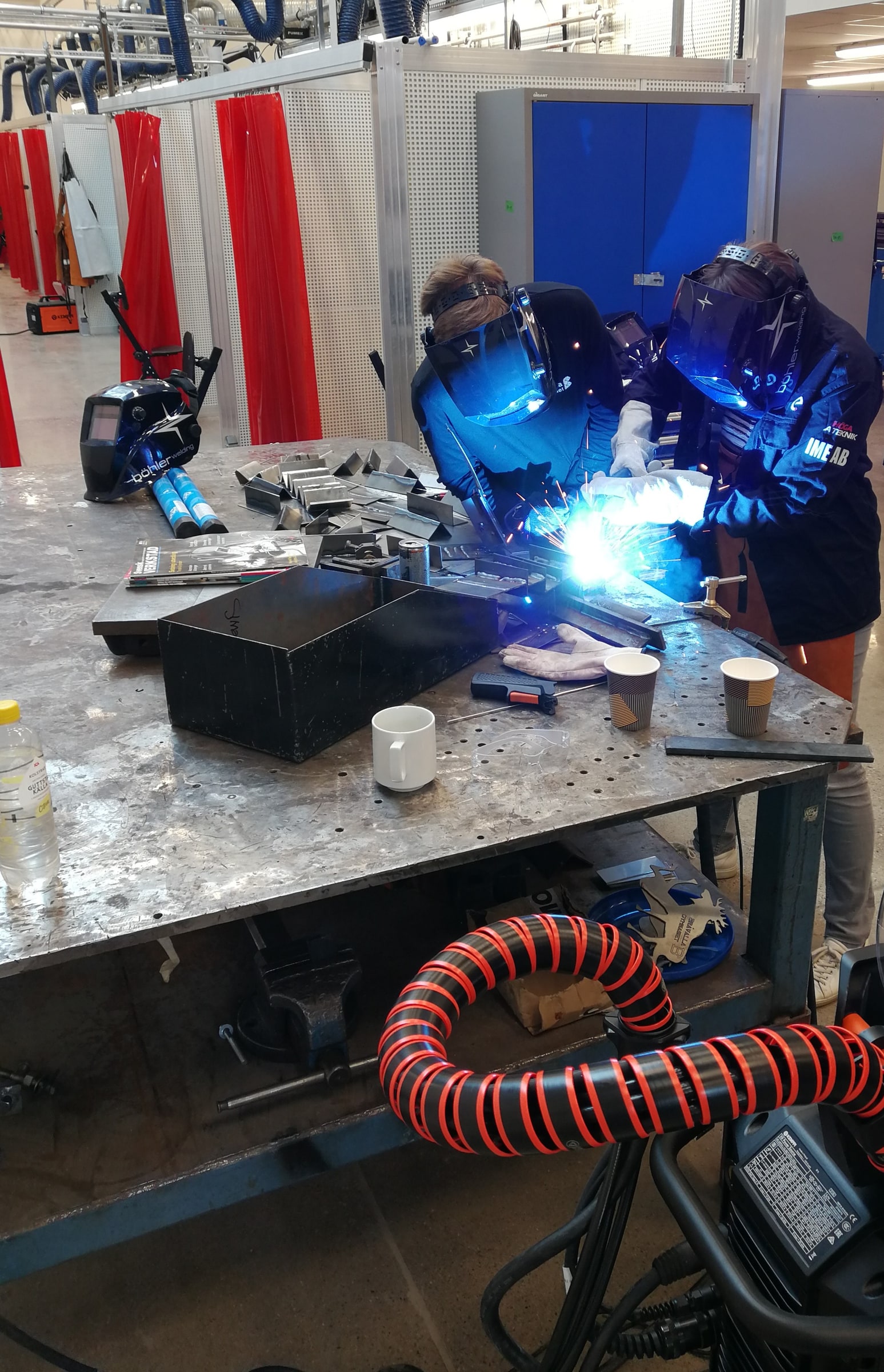 A teacher watches a student practise welding at Bråvallagymnasiet in Norrköping.