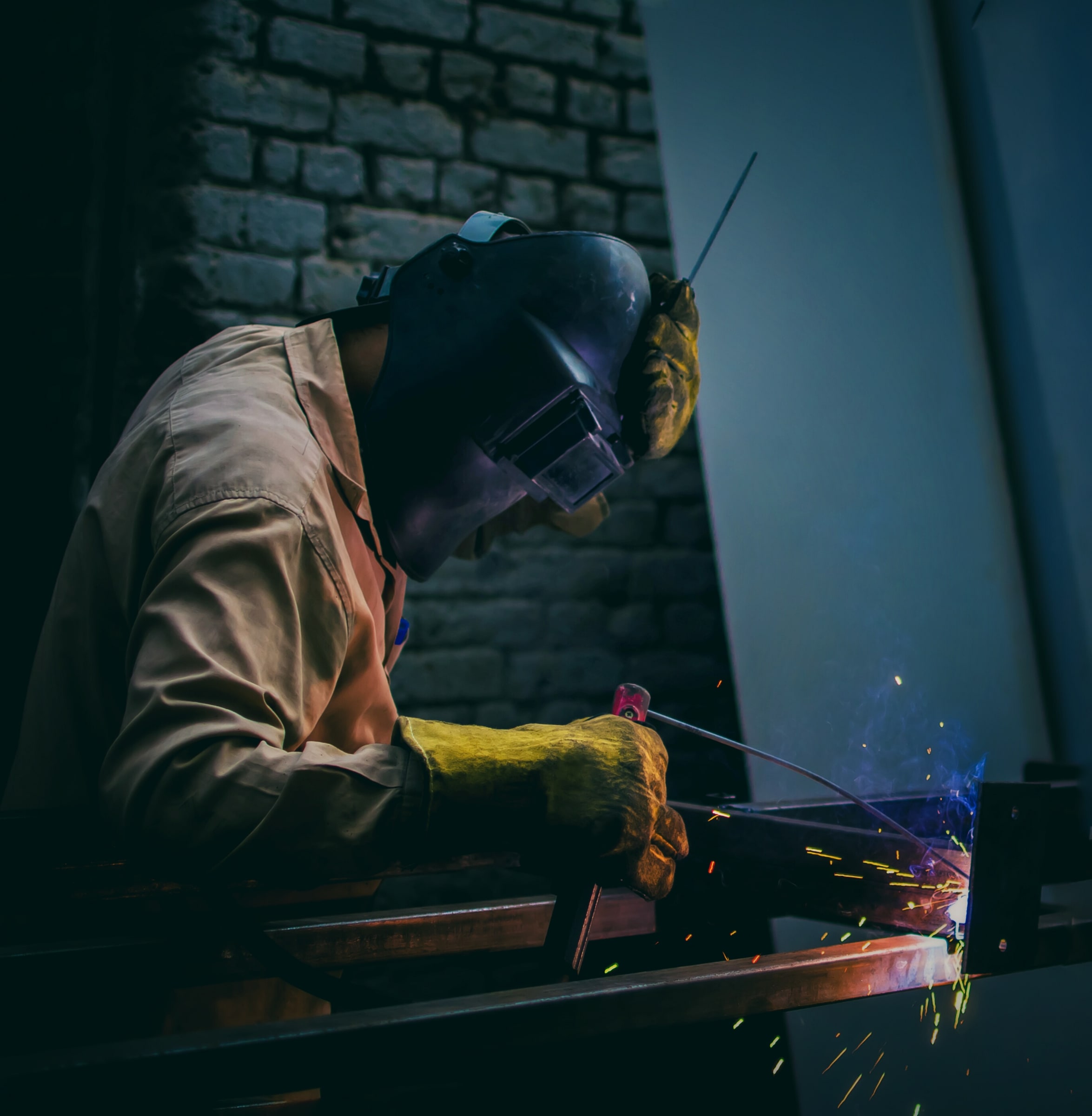 A welder wearing protective equipment works on metal in Egypt.