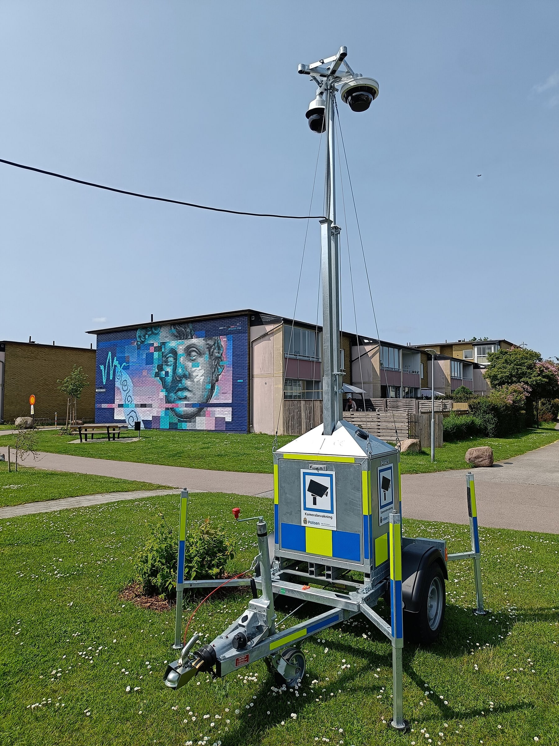 A Swedish Police mobile surveillance mast stands on a marked equipment trailer.
