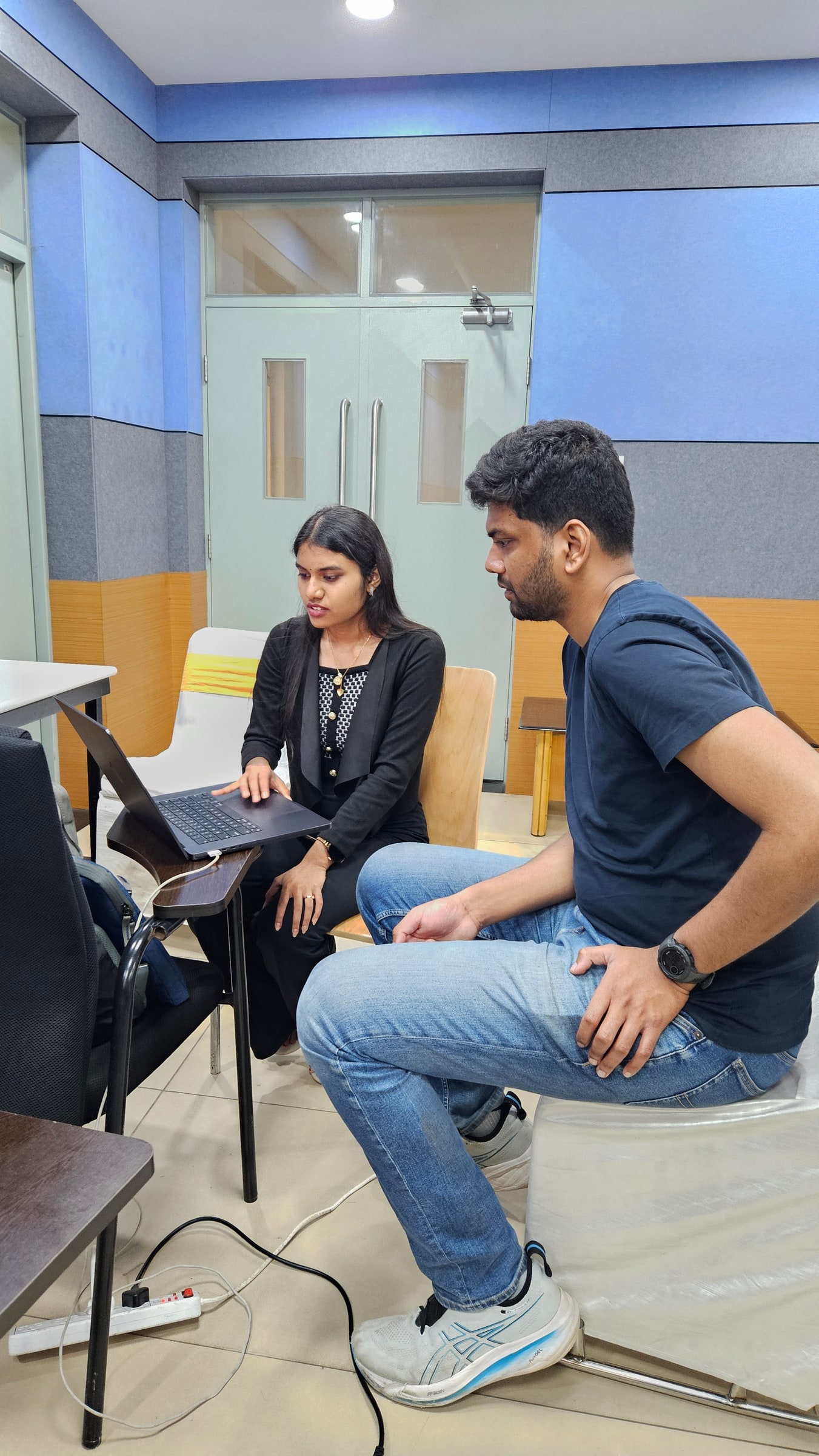 Two Indian participants collaborate on a laptop during the Indic Wikimedia Hackathon in Hyderabad in 2026.