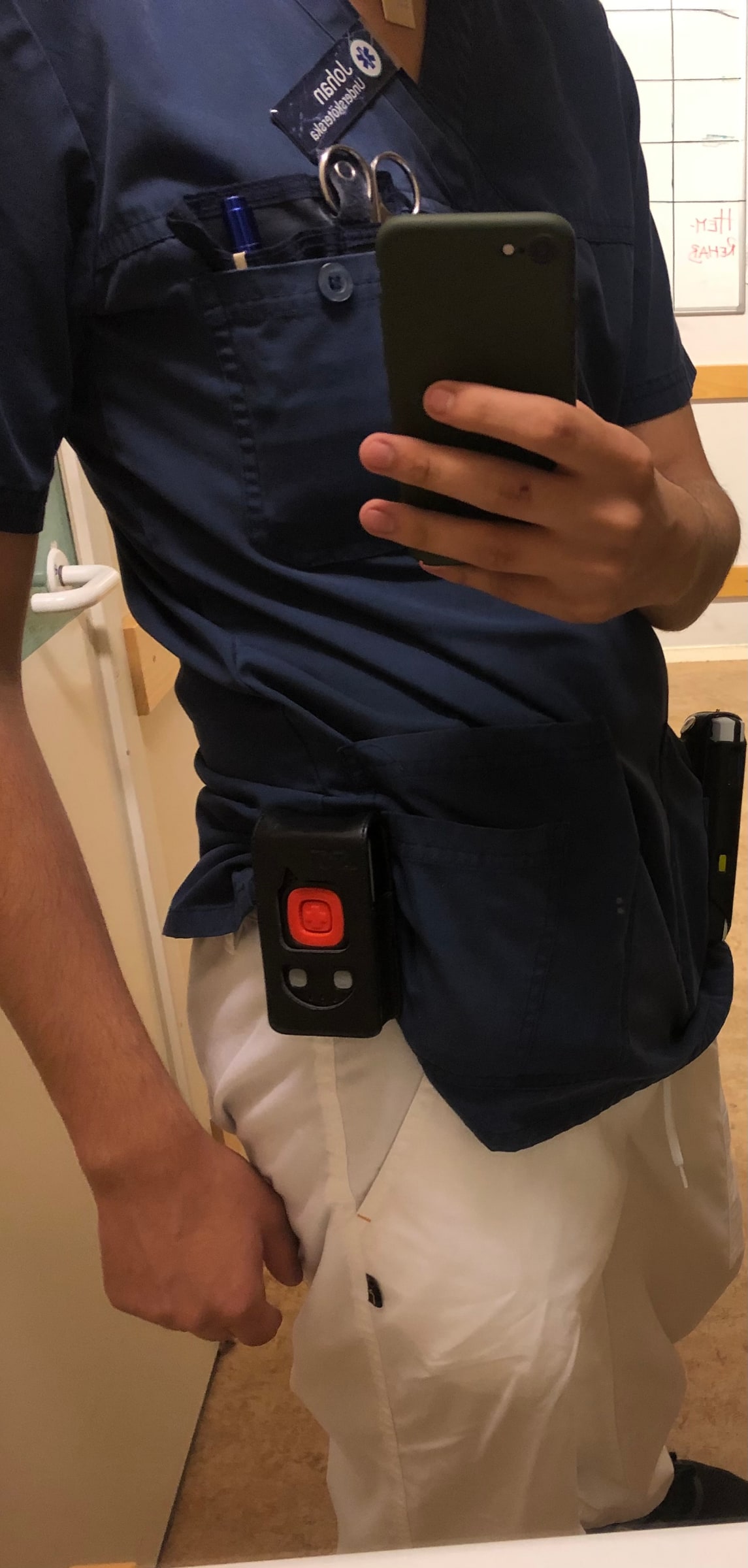 A care worker in Sweden wears a red-button assault alarm on the hip.