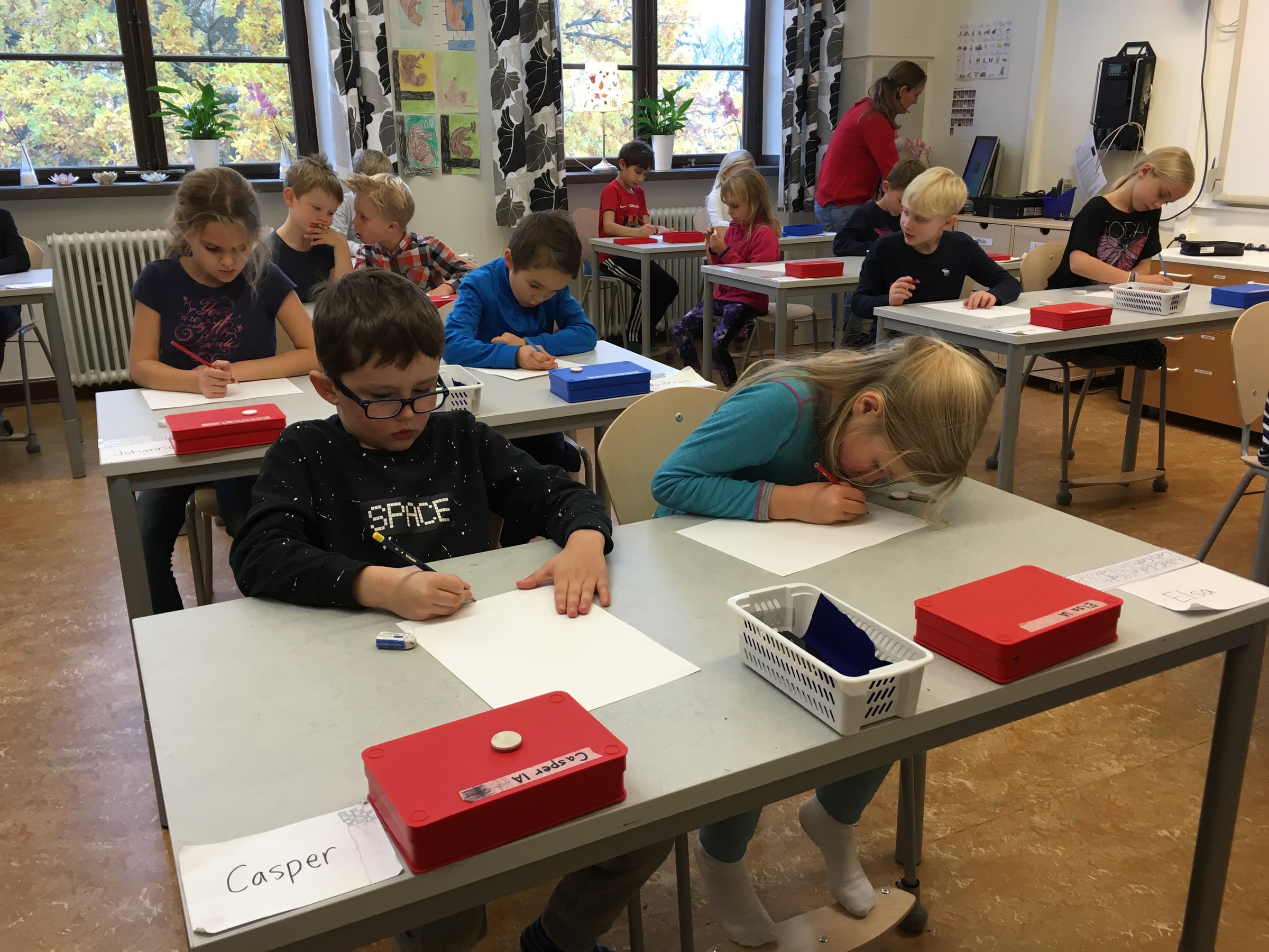 Pupils draw with pencils at classroom desks at Ålstensskolan.