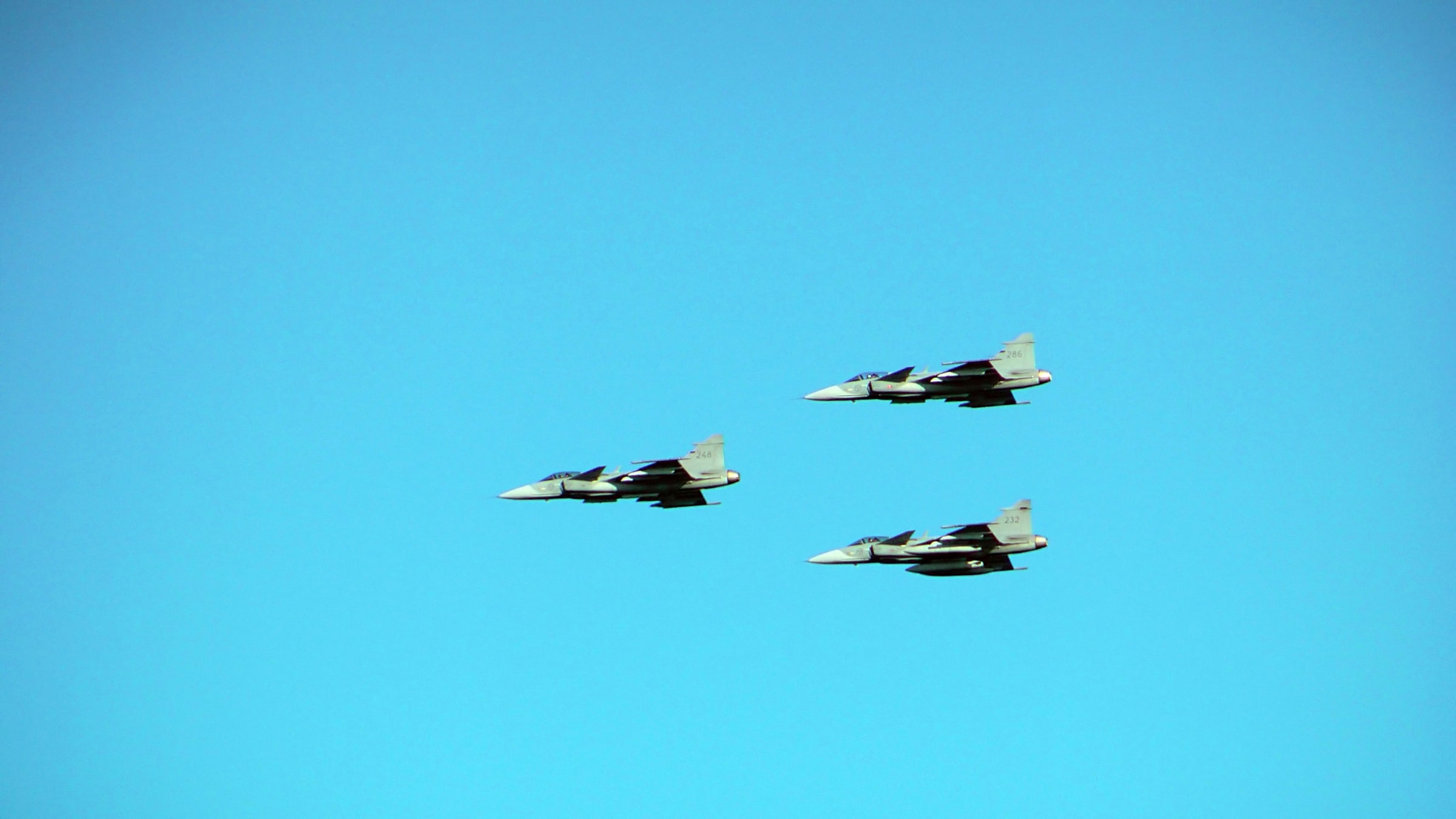 Three Swedish Air Force JAS 39 Gripen aircraft fly in formation over Helsinki in June 2017.