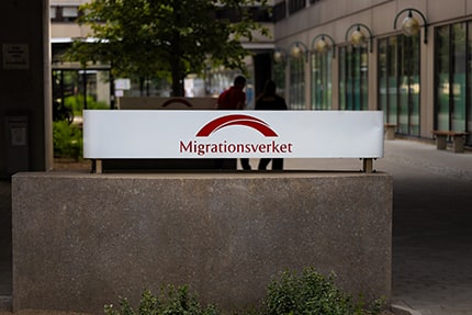 A Migrationsverket sign outside an agency building.